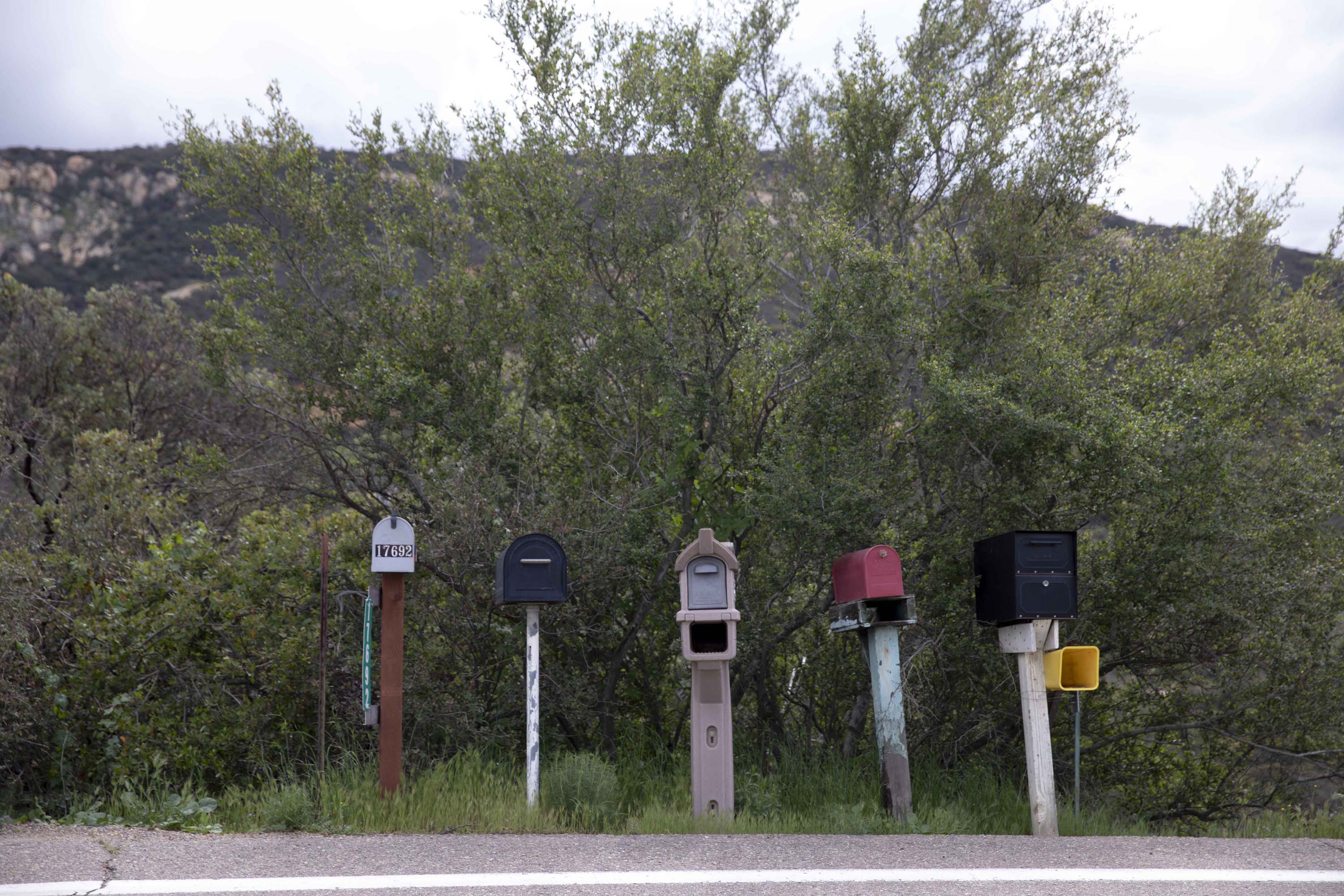 Colorful mailboxes line a dusty road in Jamul; The view from the Ituartes' mountain property overlooking San Diego in the distance.