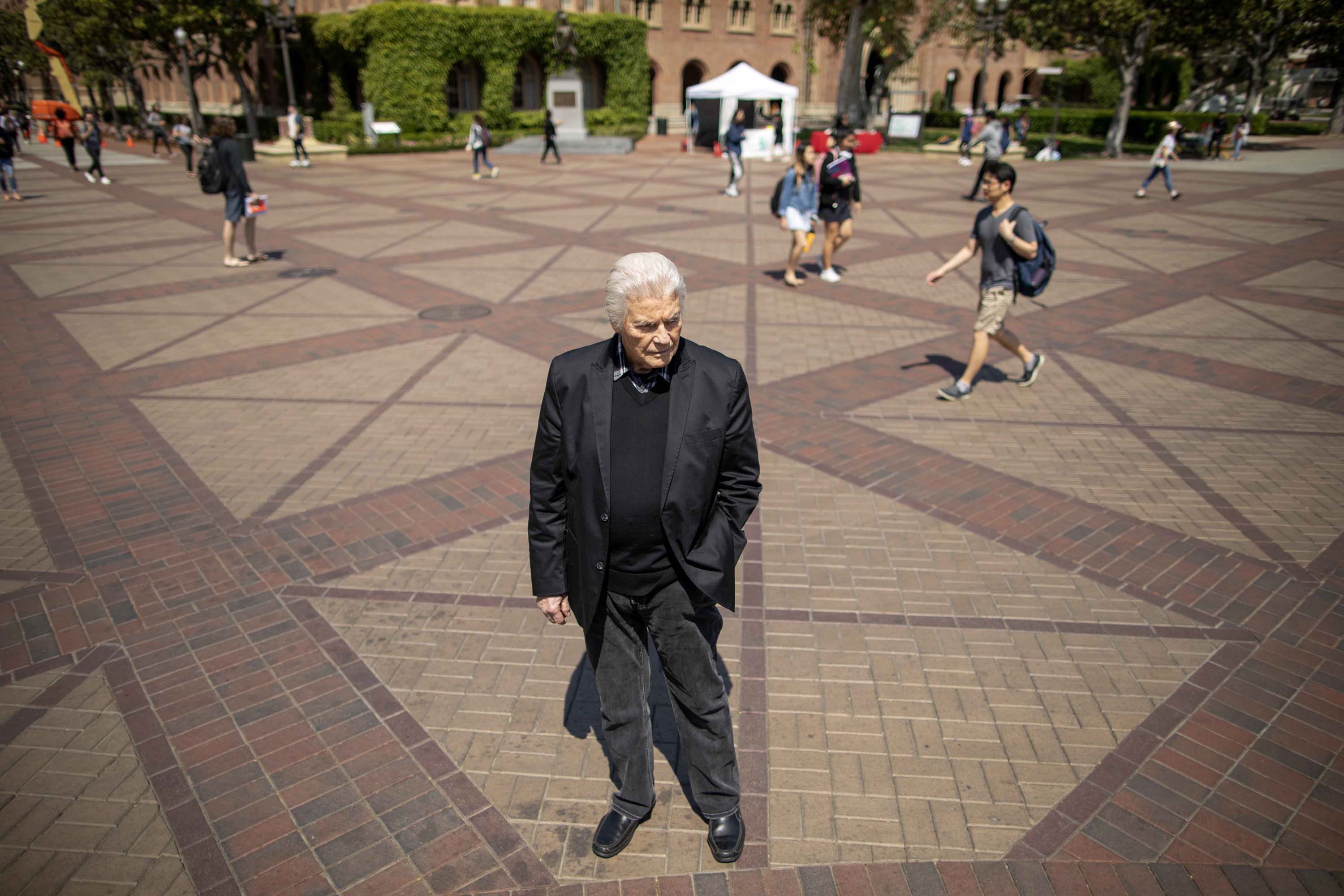 George Shannon stands on the campus of USC, where he earned his master’s degree and PhD in gerontology, and where he now works an instructional associate professor.