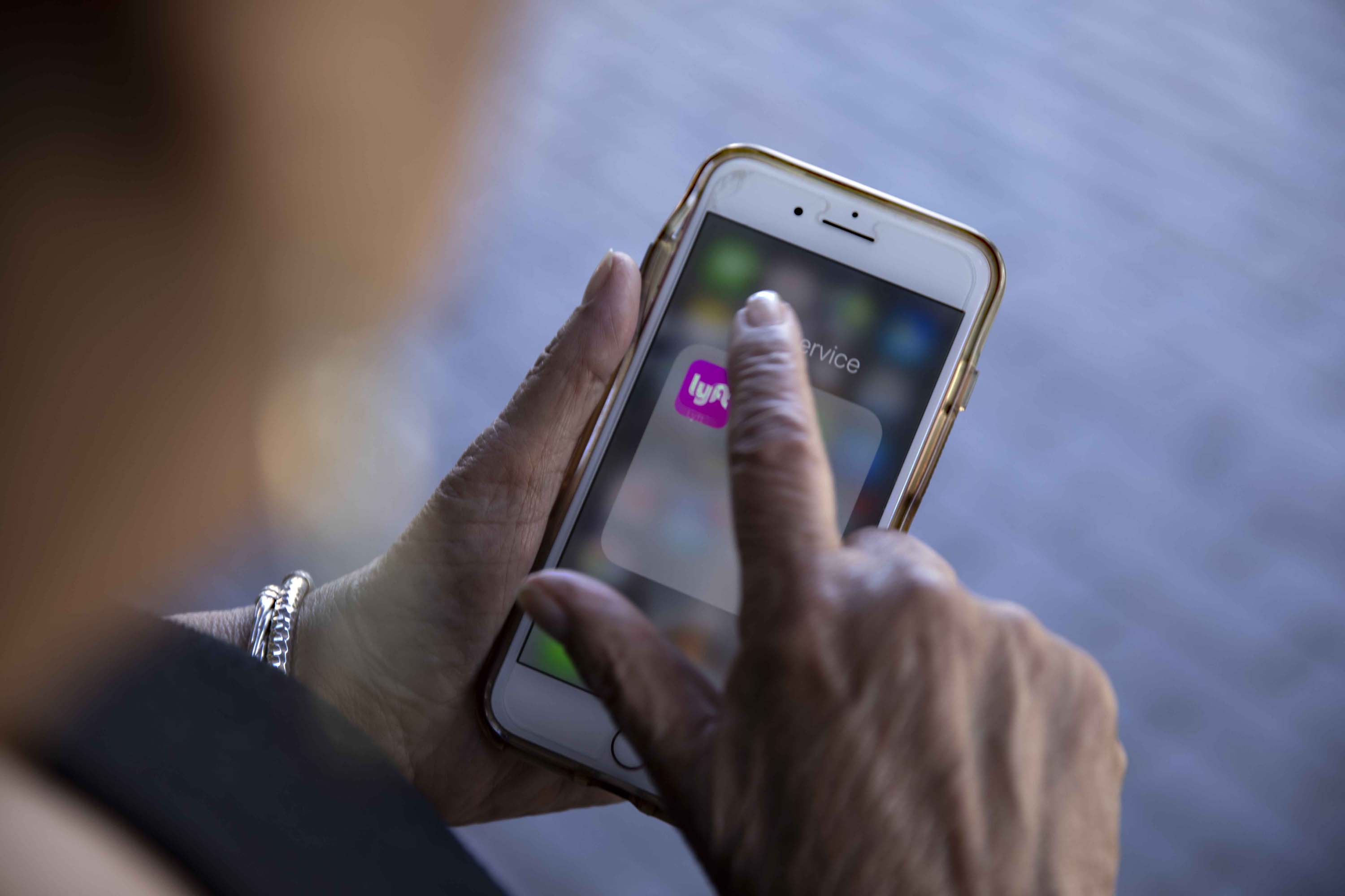 Regina Jones requests a Lyft from her phone after an opthamologist's appointment in Beverly Hills. Jones says the ride-share app is “freedom.”